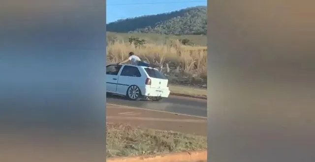 Homem é filmado deitado em teto de carro em movimento em rodovia de Goiás;